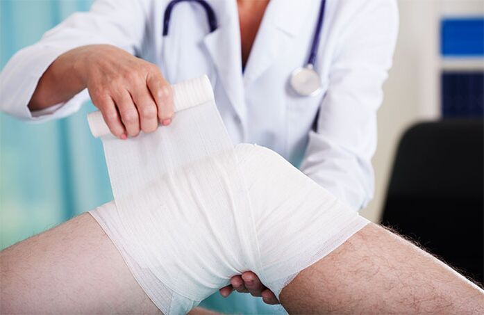 médecin bandant l'articulation du genou avec arthrose